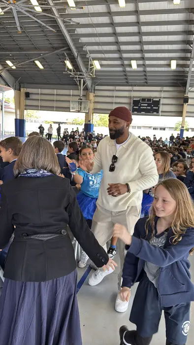 Mentor greeting young attendees at a community event