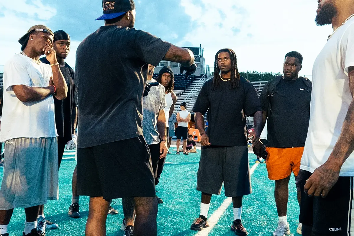 Athletes and coaches gathered on the field before a session